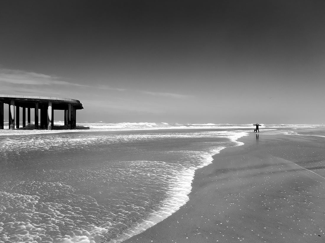 People enjoy stormy weather by the sea.