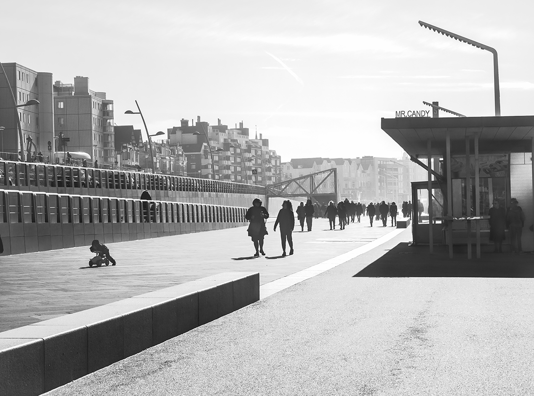 People enjoy stormy weather by the sea.