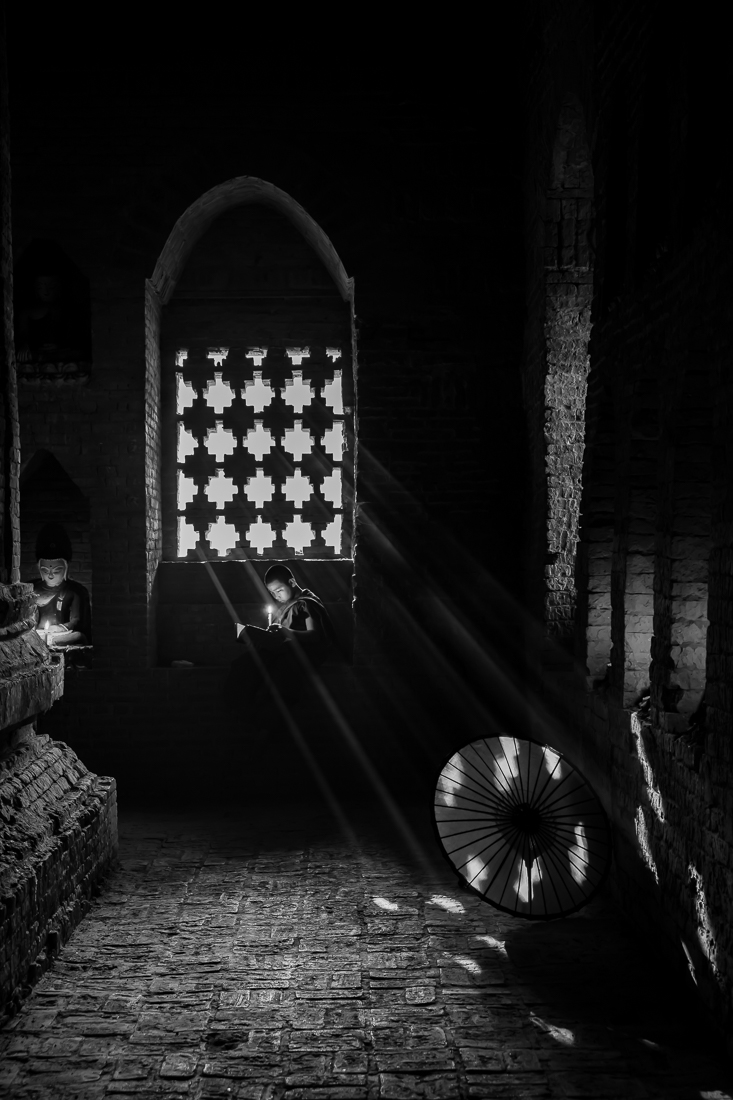 A novice reading a book in old temple