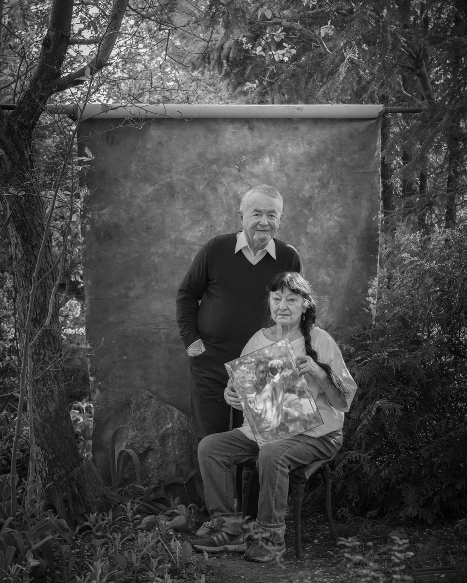 Reflected Presence. My parents in their garden while I appear as a reflection, held in my mother's hand.