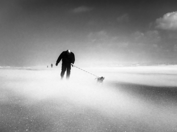 People enjoy stormy weather by the sea.